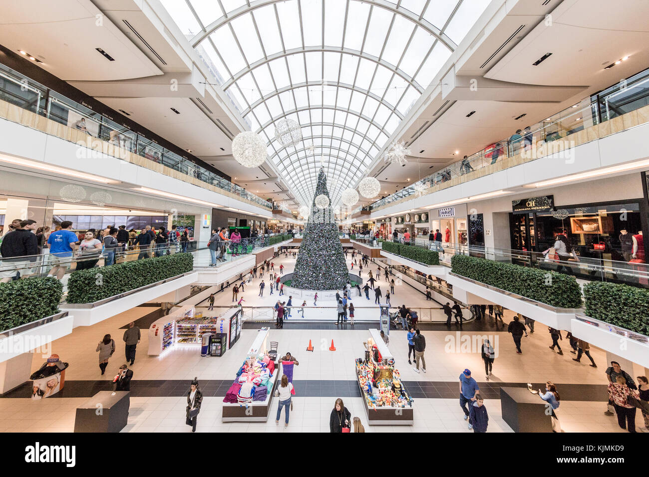 Gente occupata a vacanze di Natale lo shopping nel centro commerciale Galleria, gigantesco albero di natale e la pista di pattinaggio sul pattino visibile in distanza Foto Stock