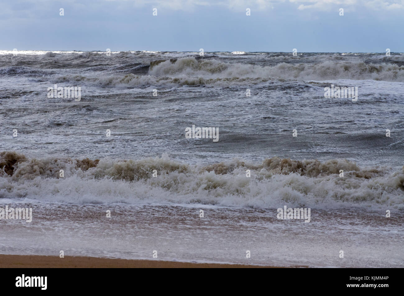 Le onde del mare nell'ombra di una nuvola e il sole Foto Stock