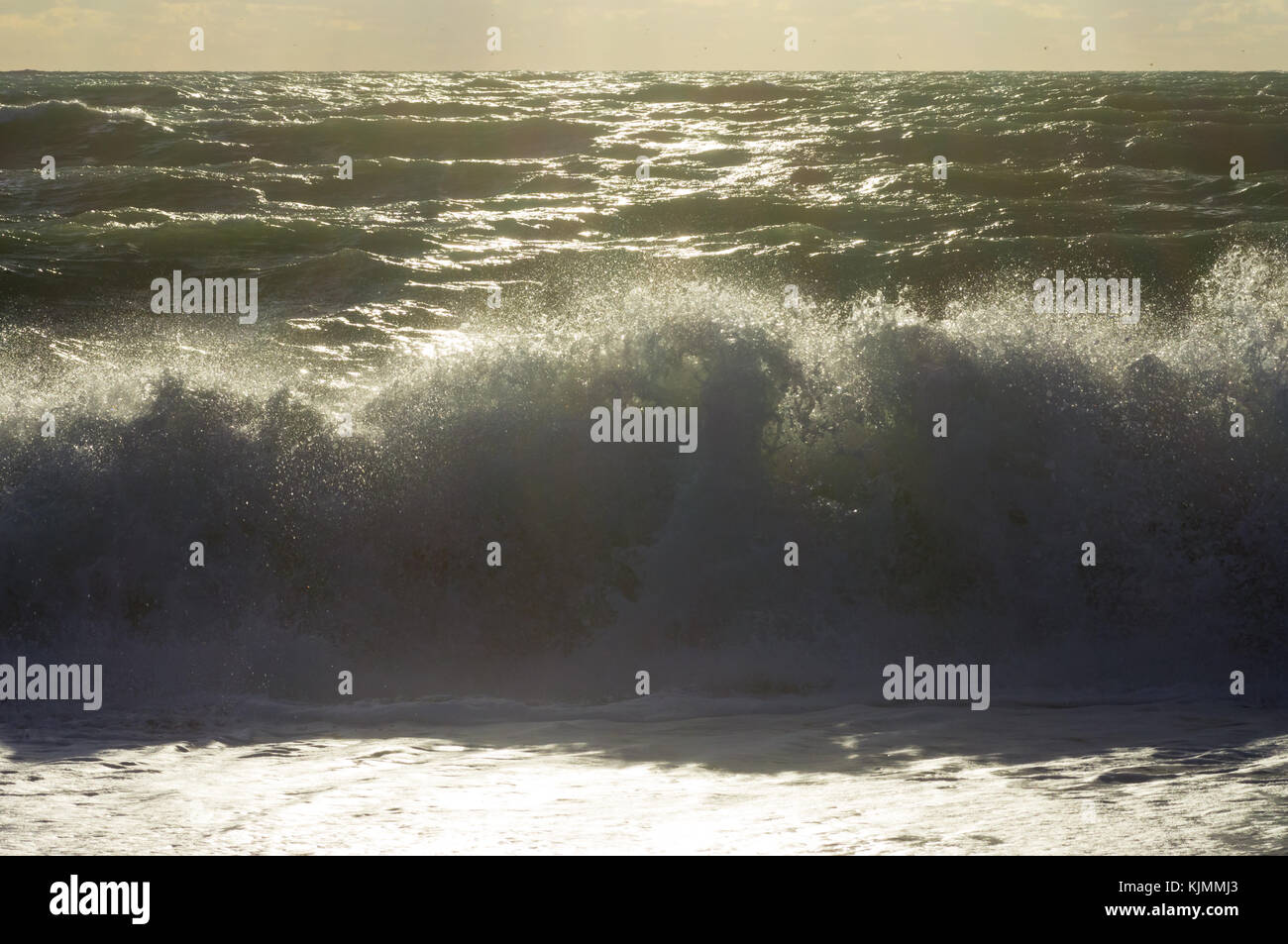 Riflessi di raggi di sole tra le onde del mare tempestoso e schizzi Foto Stock