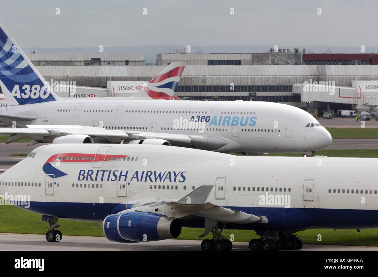 Atterraggio con inversione di spinta sulla pista 27L della prima visita di un A380 per il Regno Unito in un forte vento da sud con British Airways Boeing 747s rullaggio in Foto Stock