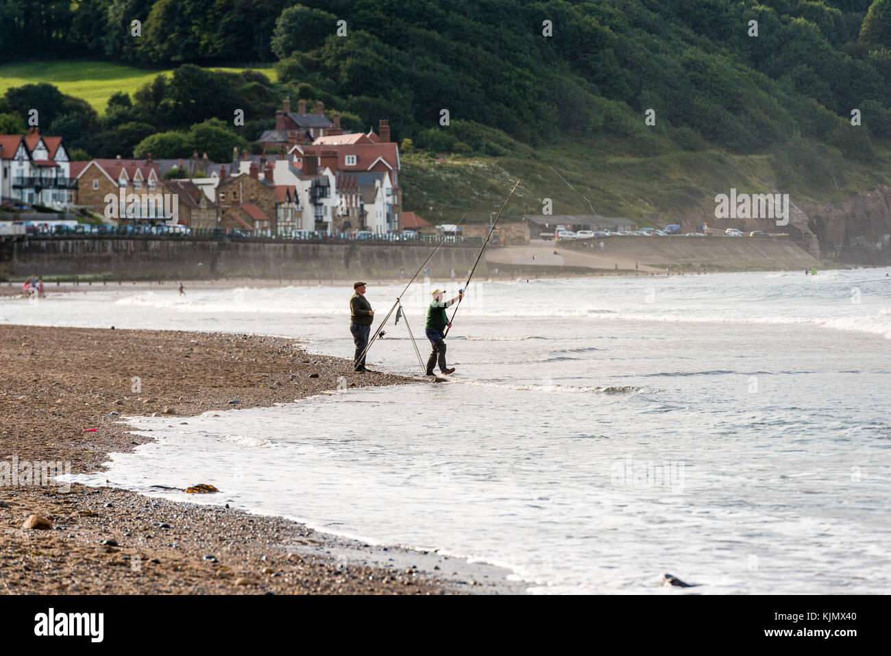 Due uomini che pescano sulla spiaggia di Sandsend, whitby, regno unito Foto Stock