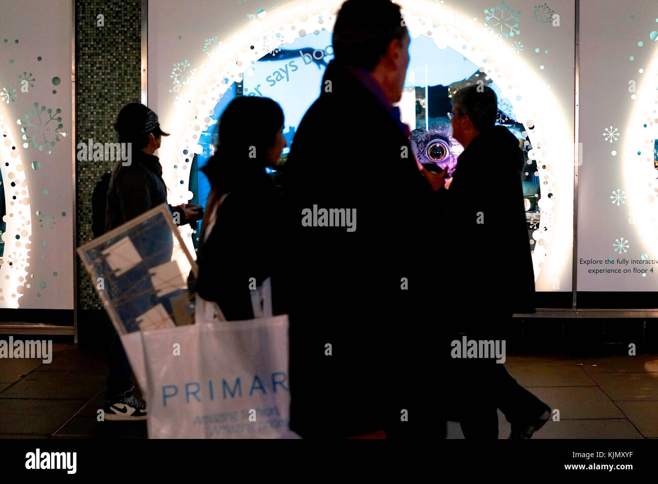 Shoppers passano davanti a John Lewis display di Natale su Oxford Street, London, Regno Unito Foto Stock