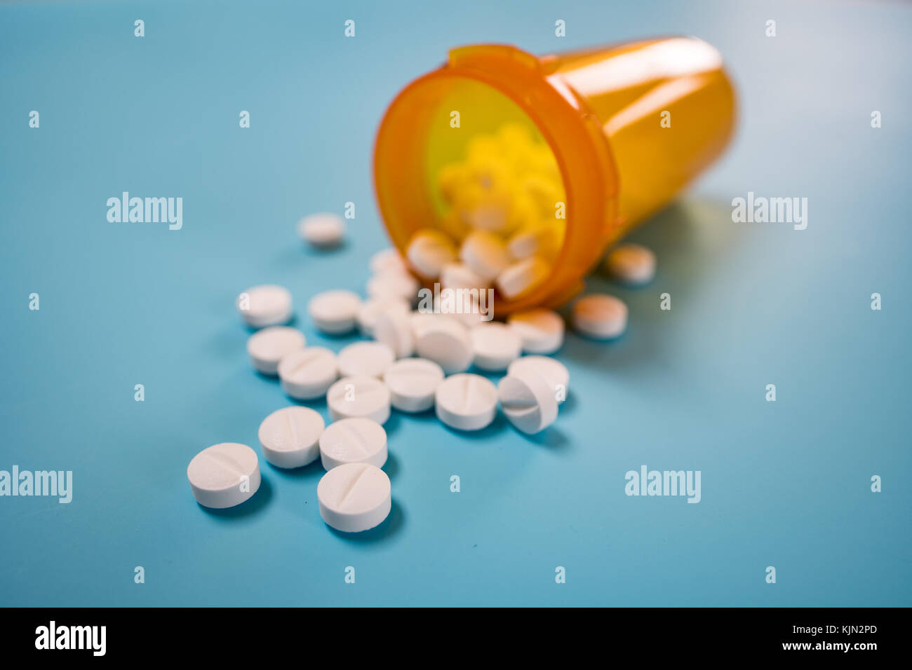 Pila di pillole di colore bianco su sfondo blu Foto Stock