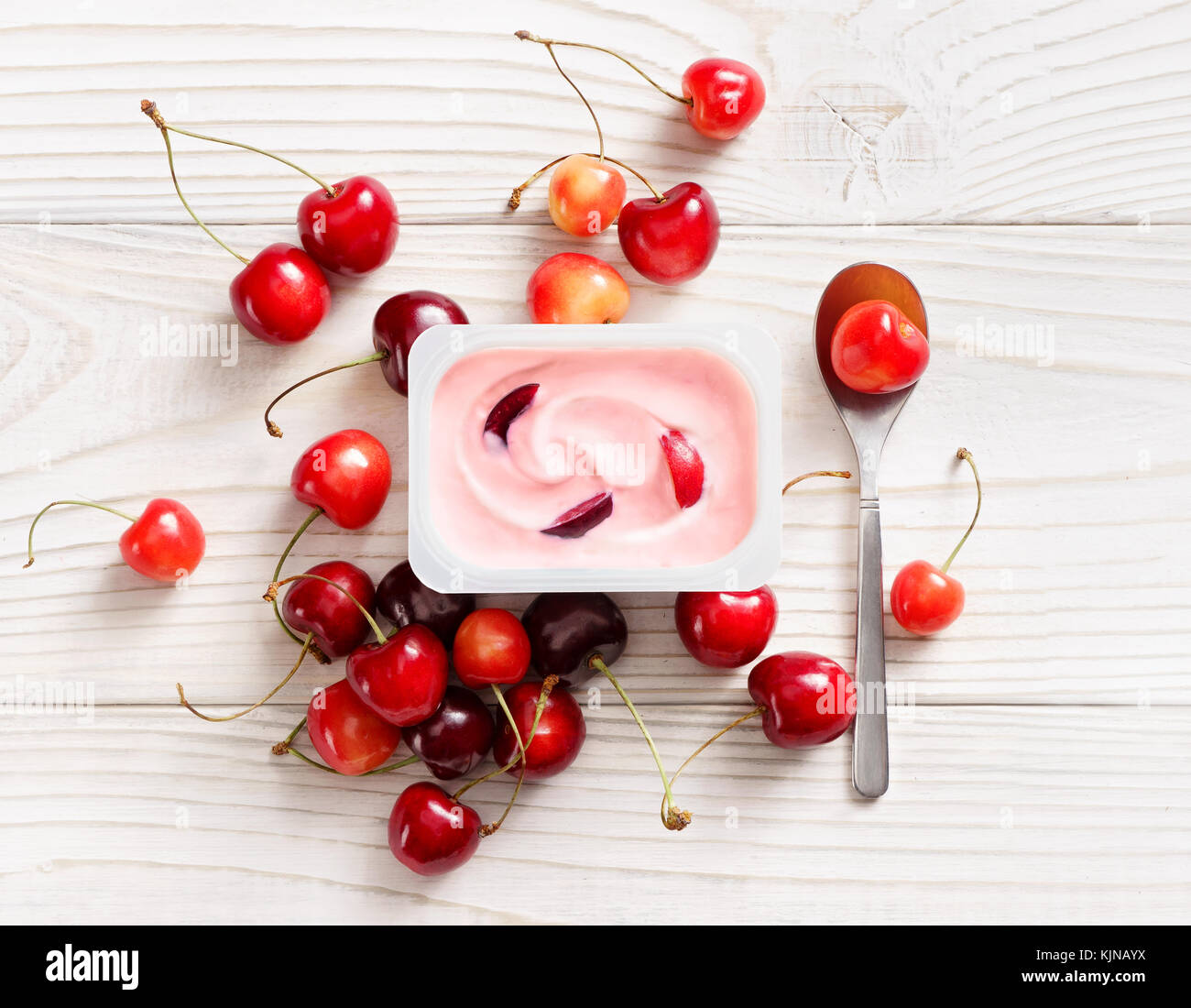 La ciliegia yogurt nel vaso in plastica su un tavolo di legno. di yogurt fresco. cibo sano concetto. alta risoluzione prodotto. vista superiore Foto Stock