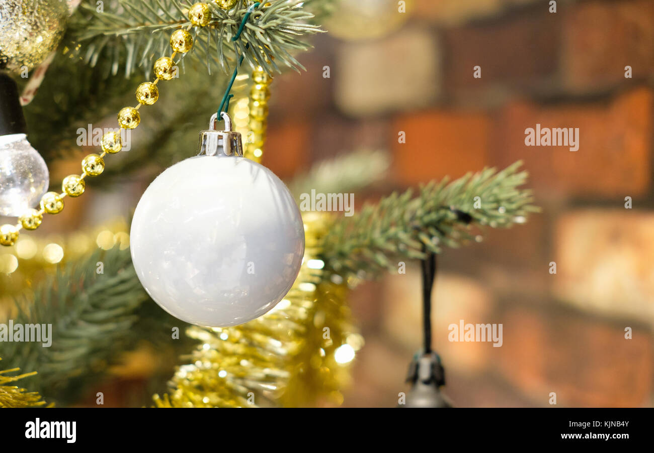 Primo piano della sfera di glitter appeso a un albero di Natale decorato. retrò effetto filtro, la selezione del punto af. Foto Stock