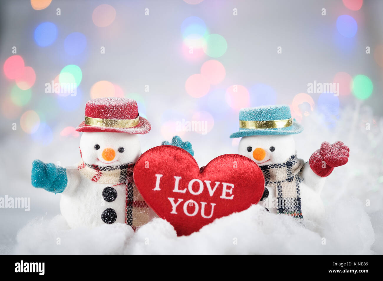 Un pupazzo di neve e mini cuore cuscino sul bokeh sfondo, con copia spazio per stagione saluto. Buon Natale o felice anno nuovo, la selezione del punto af, classe Foto Stock