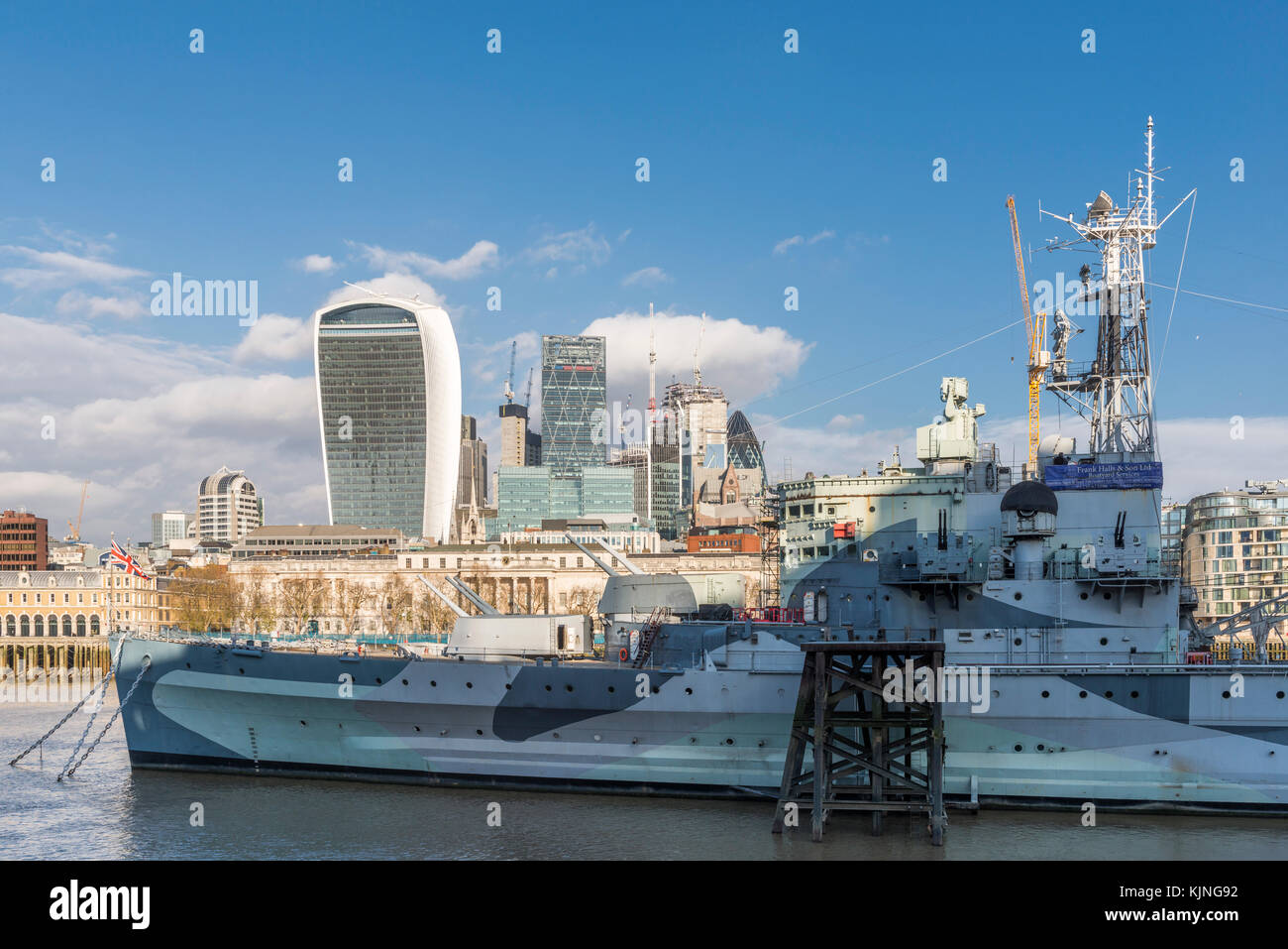 Il fiume Tamigi con HMS Belfast, london, Regno Unito con la City of London financial district sfondo su una soleggiata giornata autunnale Foto Stock