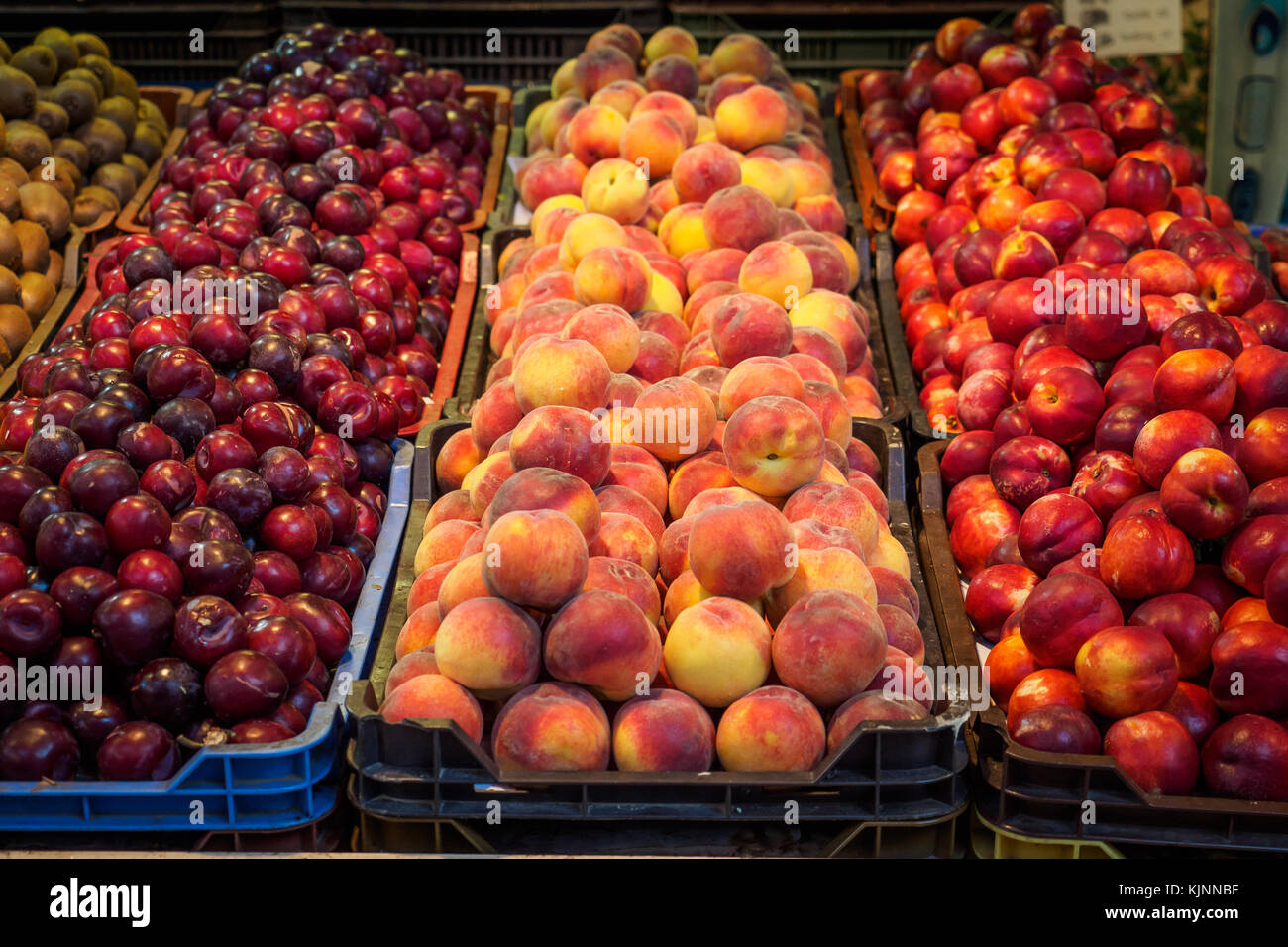 Diverse varietà di pesche in vendita in un mercato locale. Formato orizzontale. Foto Stock