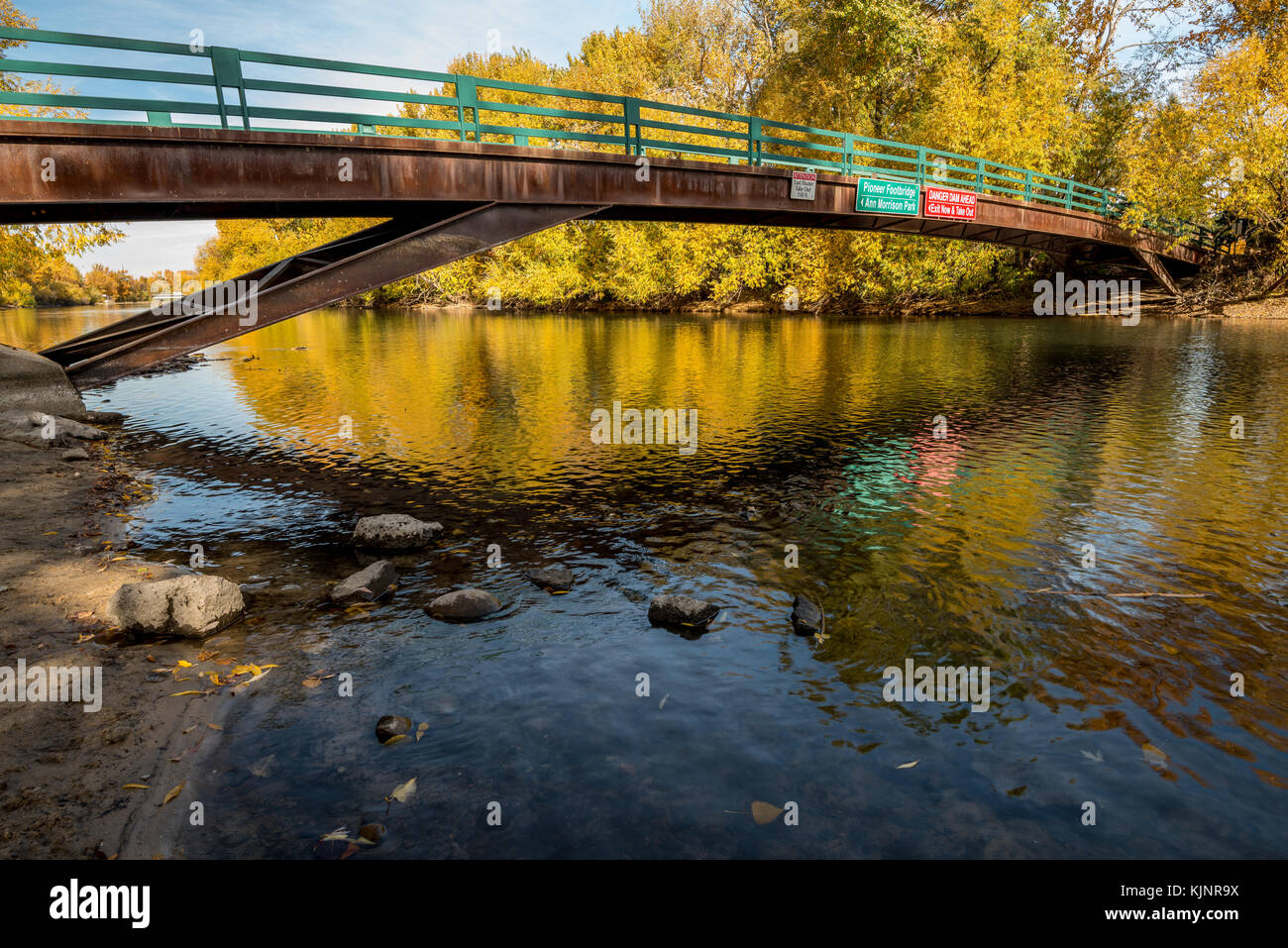 Autumn Tree riflessione può essere visto in acqua sotto un ponte Foto Stock