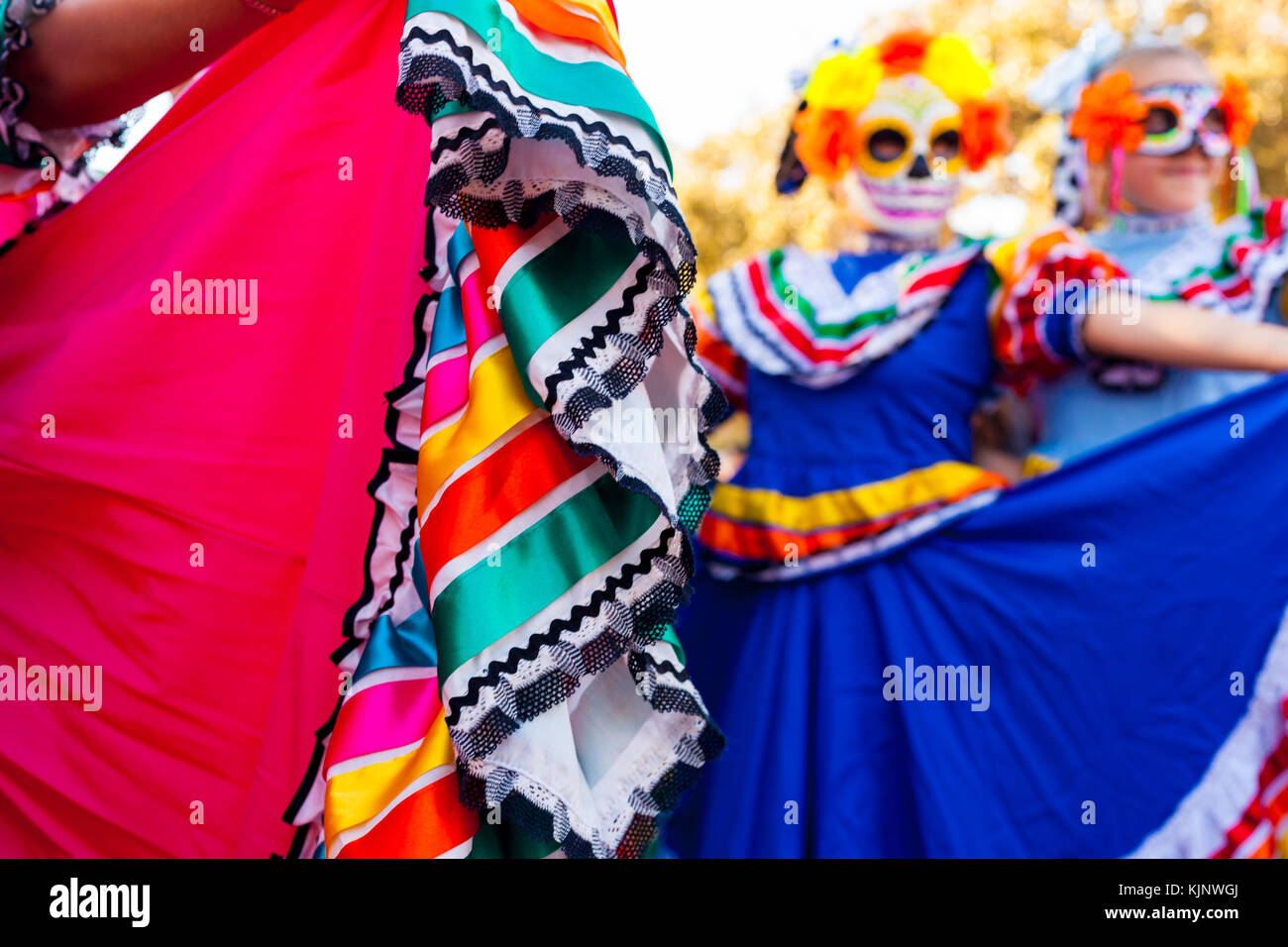 Close up dettaglio di abbigliamento tradizionale e sfondo sfocato di ragazze con le maschere che frequentano il dia de los Muertos/giorno dei morti la celebrazione Foto Stock