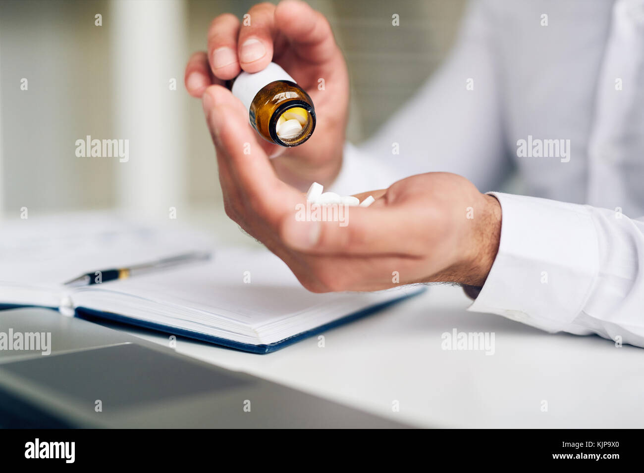 Imprenditore andando a prendere antidolorifico al lavoro durante la giornata stressante Foto Stock