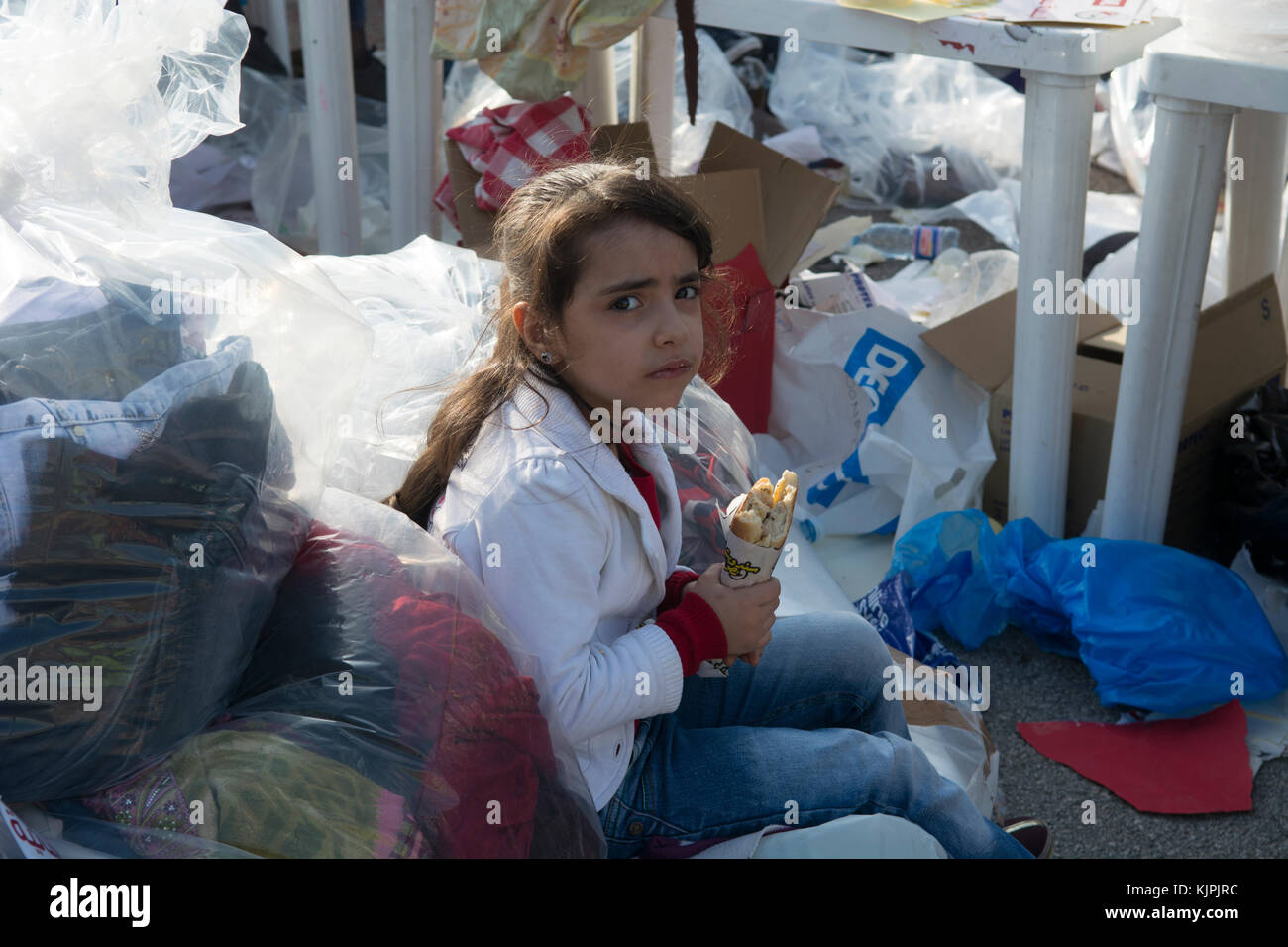 Marytrs' Square, Beirut, Libano, 26 Nov 2017, poco siriano ragazza di rifugiati a mangiare accanto ai vestiti e le donazioni di sacchetti di Beirut, Libano, Credito: Mohamad Itani / Alamy Live News Foto Stock