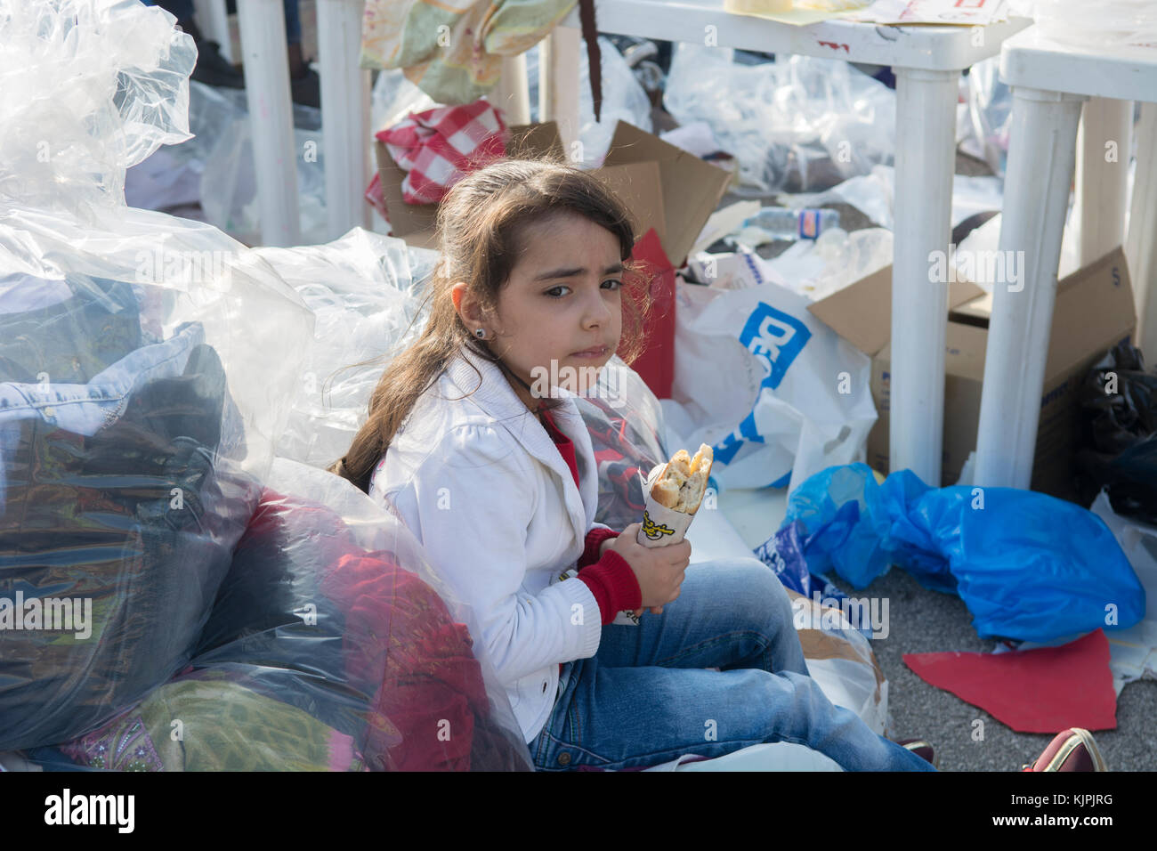 Marytrs' Square, Beirut, Libano, 26 Nov 2017, poco siriano ragazza di rifugiati a mangiare accanto ai vestiti e le donazioni di sacchetti di Beirut, Libano, Credito: Mohamad Itani / Alamy Live News Foto Stock