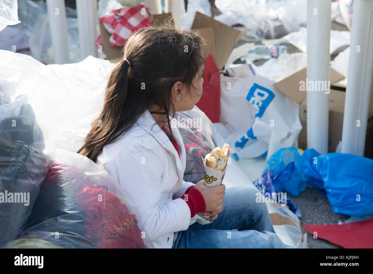 Marytrs' Square, Beirut, Libano, 26 Nov 2017, poco siriano ragazza di rifugiati a mangiare accanto ai vestiti e le donazioni di sacchetti di Beirut, Libano, Credito: Mohamad Itani / Alamy Live News Foto Stock