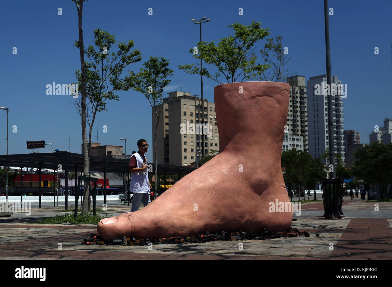 Sao Paulo, Brasile. 29 nov, 2017. Un uomo orologi una scultura di un gigante passo passo del piede sulla brace di artista brasiliano eduardo srur, in sao paulo, Brasile, il nov. 29, 2017. La scultura ha l obiettivo di creare consapevolezza sul familial polineuropatia amiloide, una malattia neurologica in cui uno dei possibili sintomi è la ridotta capacità di sentire la temperatura. Credito: rahel patrasso/xinhua/alamy live news Foto Stock