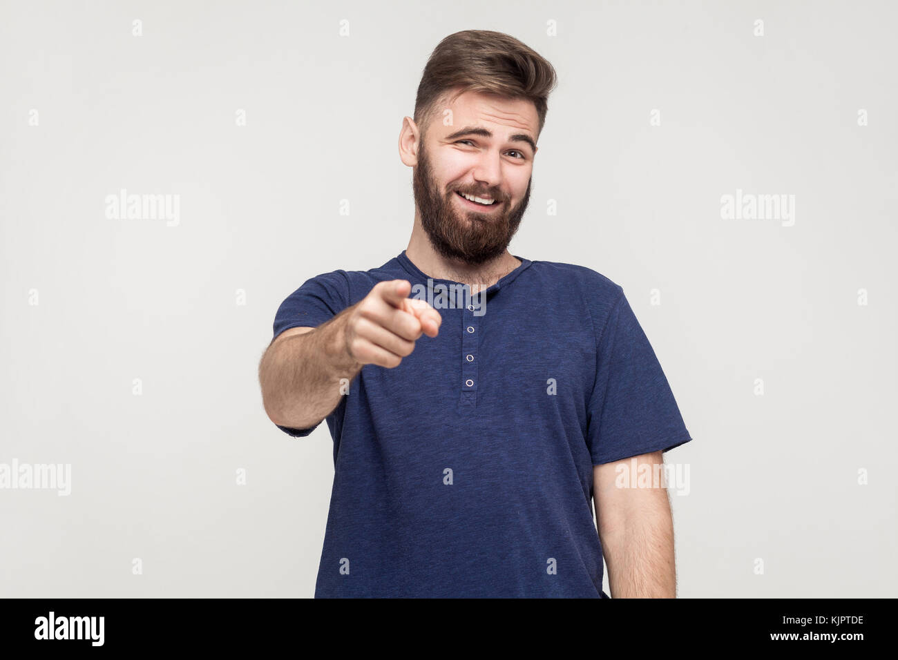 Strambata, bad taunt concetto. giovane uomo adulto puntare il dito e il sorriso toothy. studio shot, sfondo grigio Foto Stock