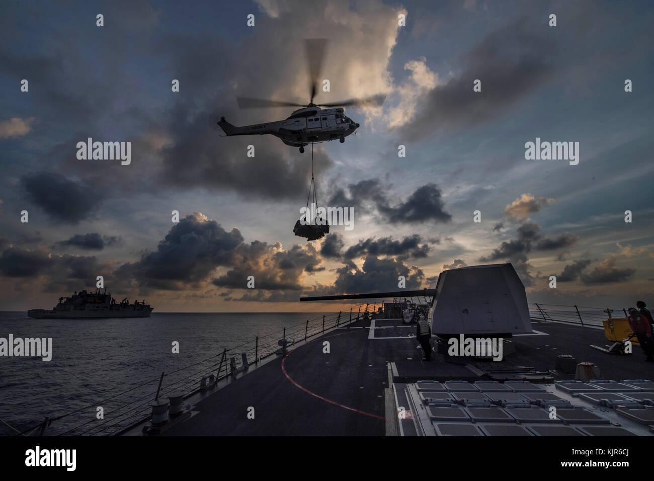 SA-330 Puma offre un carico durante un rifornimento verticale a bordo del Arleigh Burke-class guidato- Foto Stock