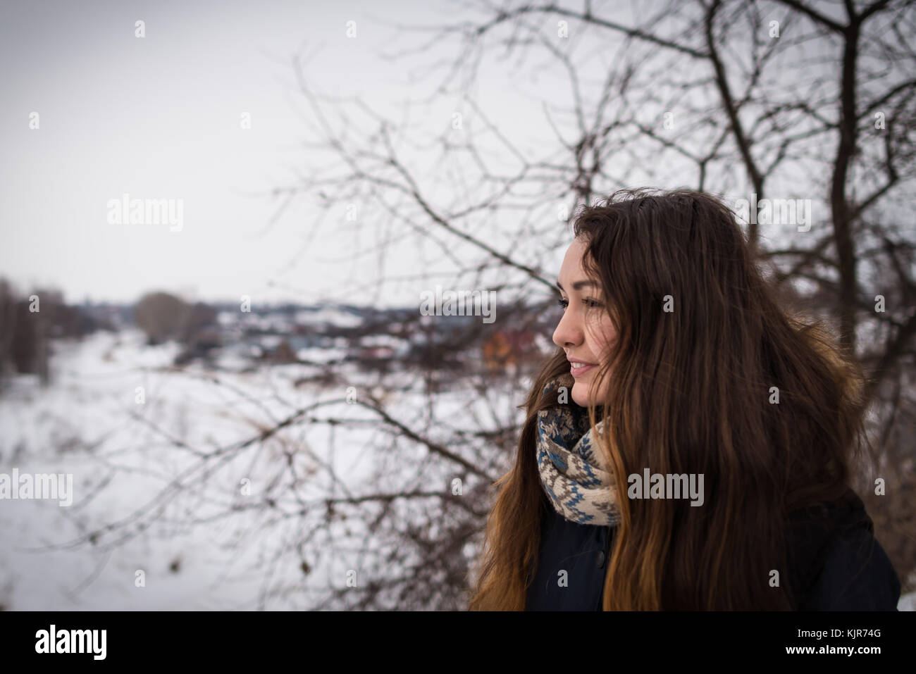 Malinconici e ragazza romantica con bellissimi capelli lunghi sullo sfondo inverno guardando lontano sul paesaggio invernale Foto Stock