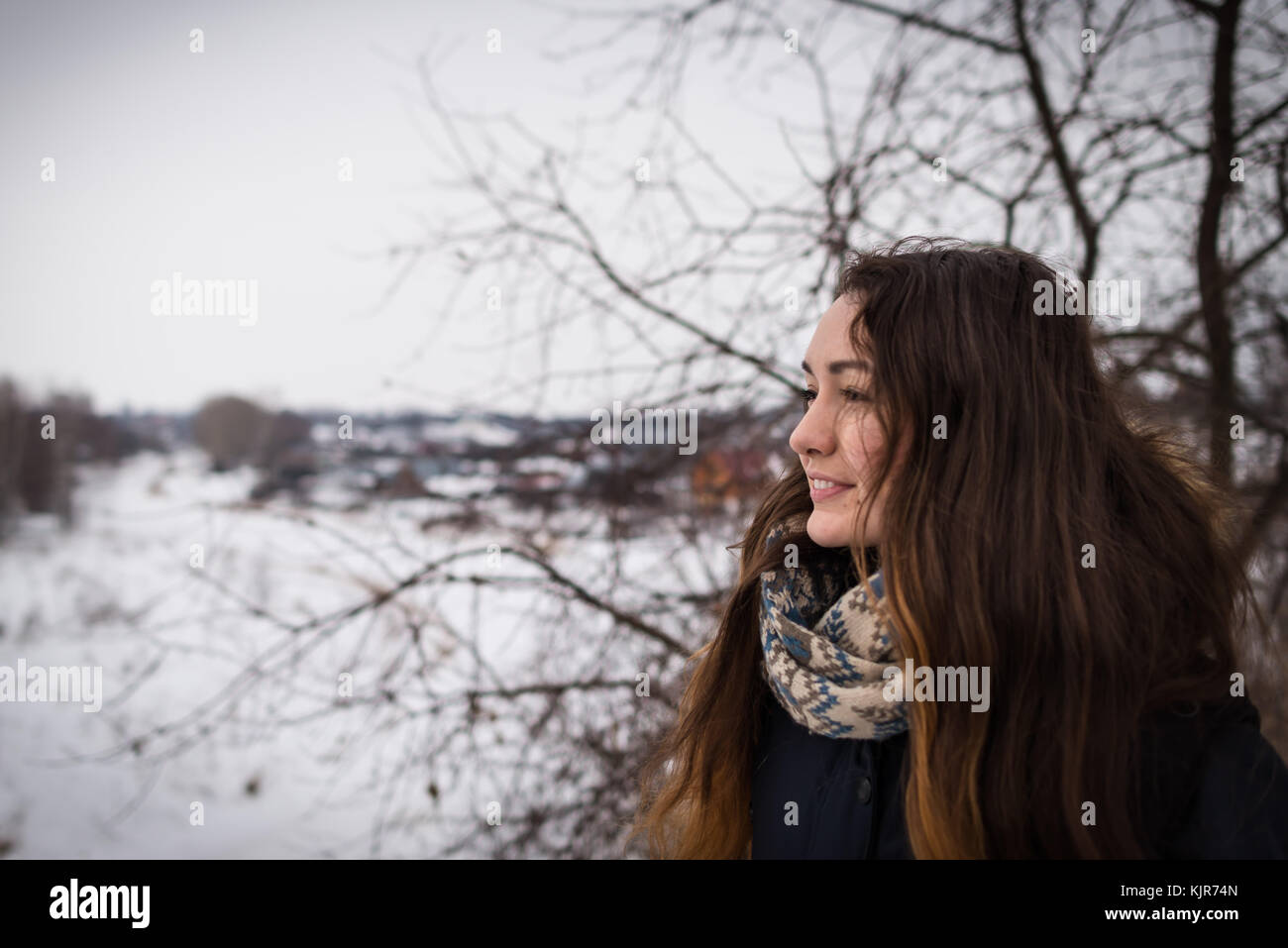 Malinconici e ragazza romantica con bellissimi capelli lunghi sullo sfondo inverno guardando lontano sul paesaggio invernale Foto Stock