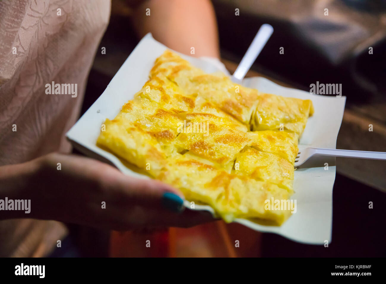 Donna tenendo la piastra di pancake al cibo in stallo Foto Stock