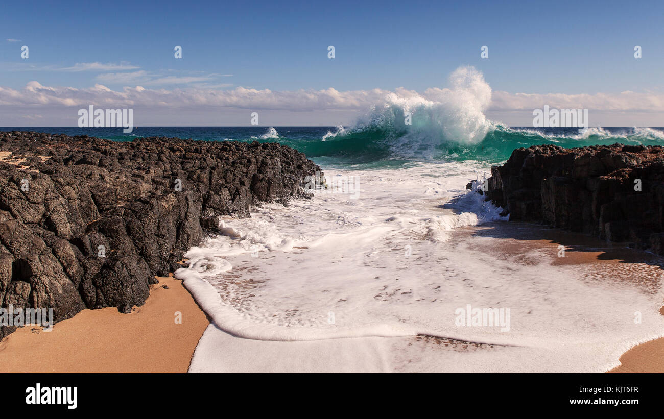 Aumento dell'onda vicino a terra prima che si infrangono sulle rocce Foto Stock