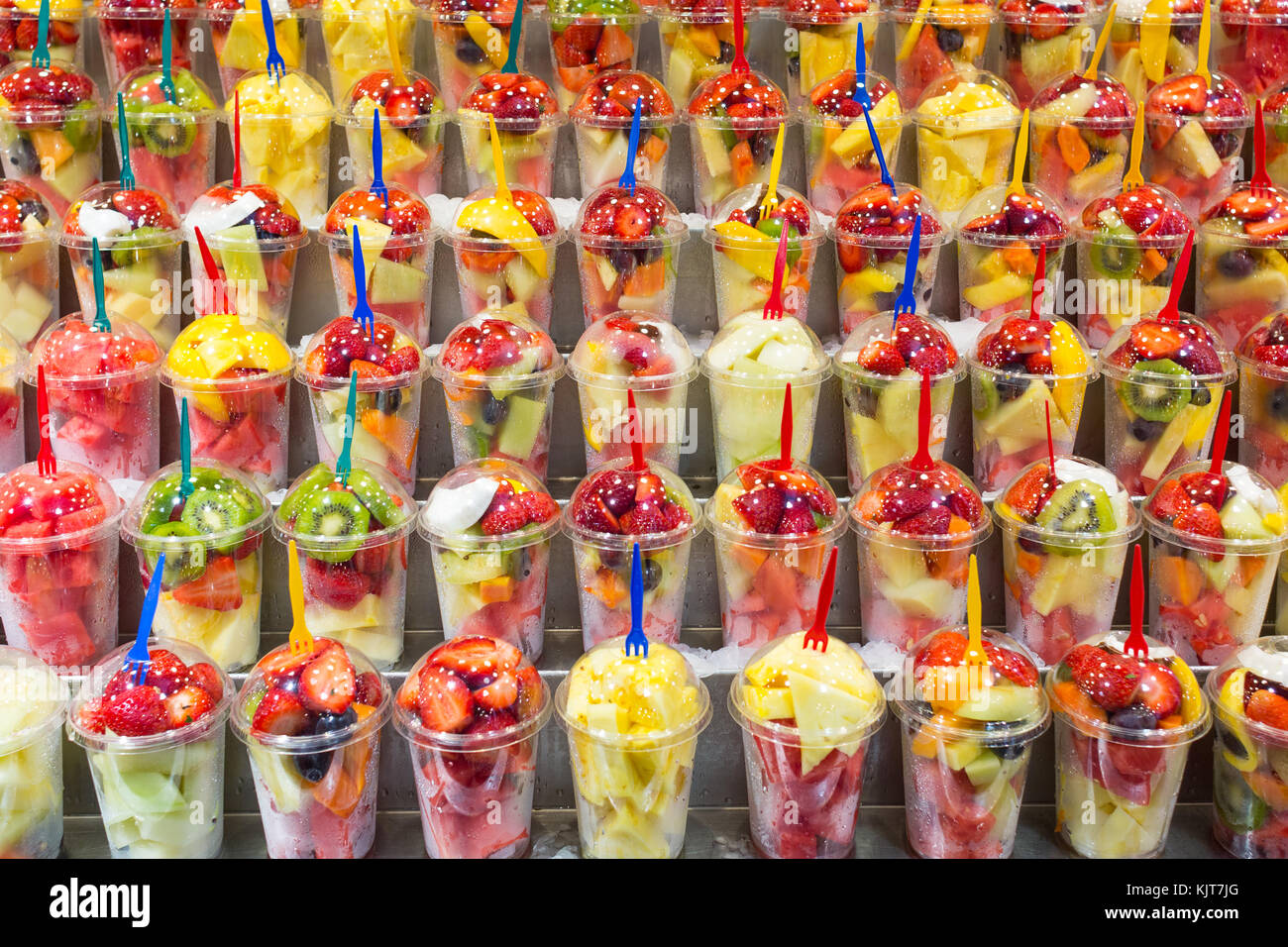 I Bicchieri Di Plastica Di Frutta Tagliata Fragole Kiwi Ananas Cocos Mango Melone Con Forche Sul Display Per La Vendita Foto Stock Alamy