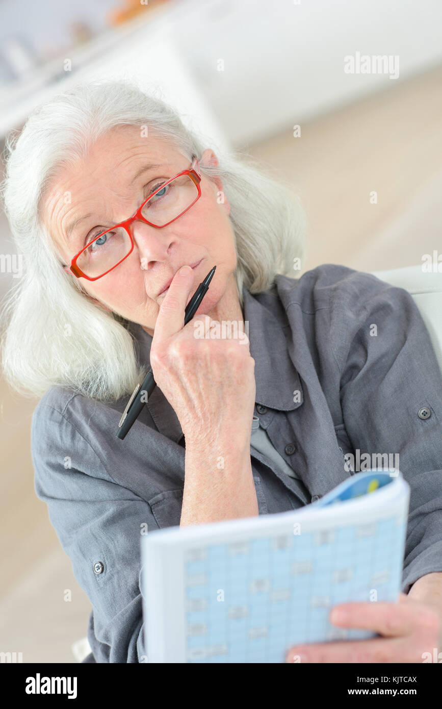 Premurosa donna anziana facendo il cruciverba Foto Stock