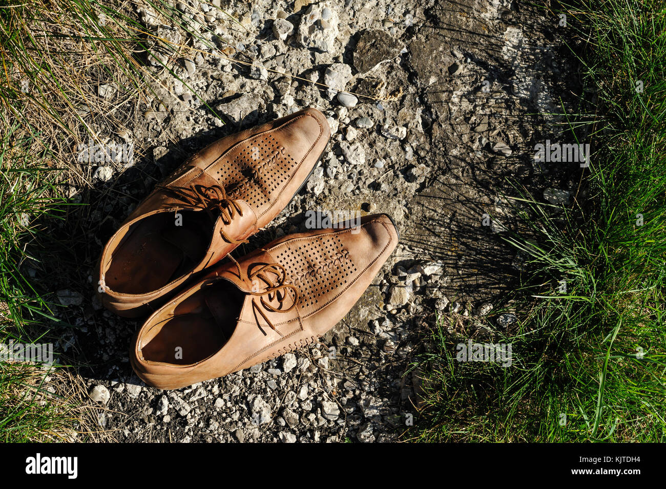 Vecchie scarpe da uomo sulla pista in erba. Foto Stock