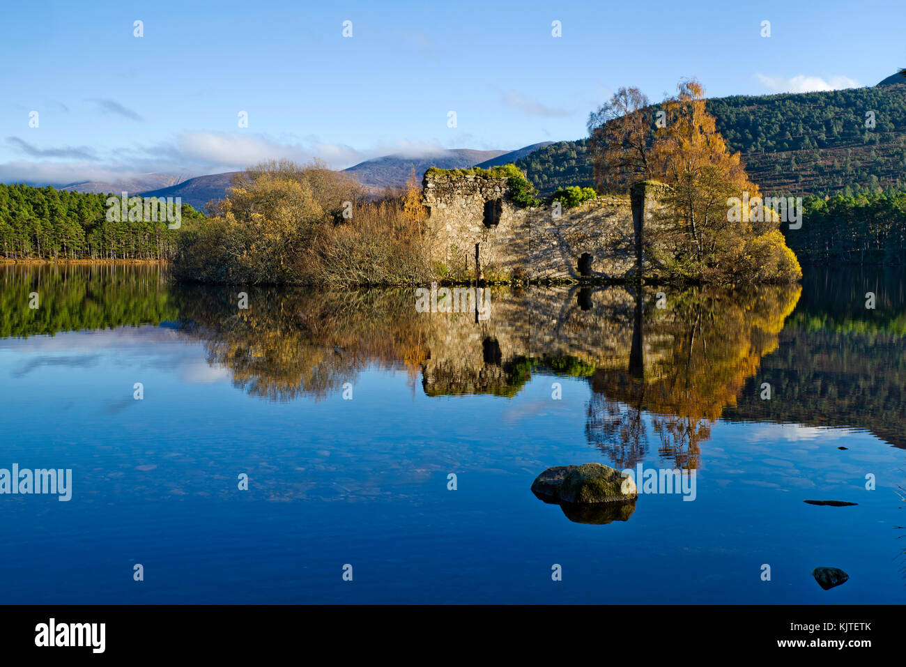 Loch un Eilein, Rothiemurchus, Cairngorms, Highlands scozzesi, UK. Il vecchio rovinato castello isola riflessa nei loch su una splendida e tranquilla giornata d'autunno. Foto Stock