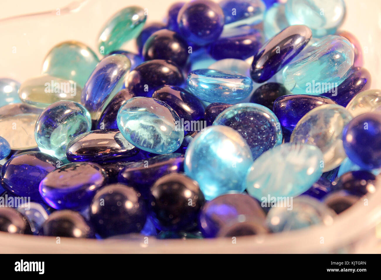 Close up di vetro blu e teal marmi in un contenitore di vetro Foto Stock