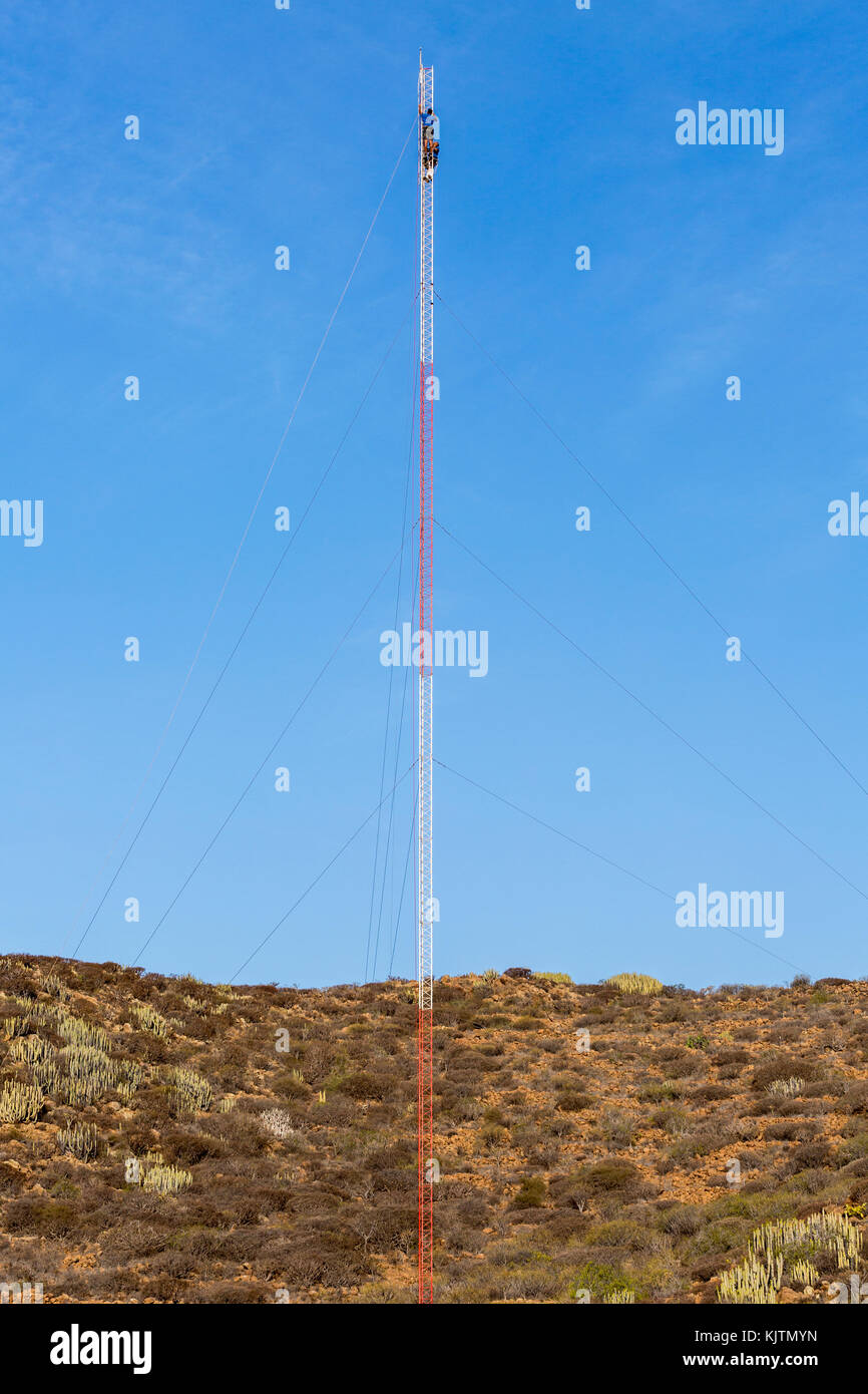 Gli uomini al lavoro sulla parte superiore di un montante di comunicazioni contro un cielo blu, Tenerife, Isole Canarie, Spagna Foto Stock