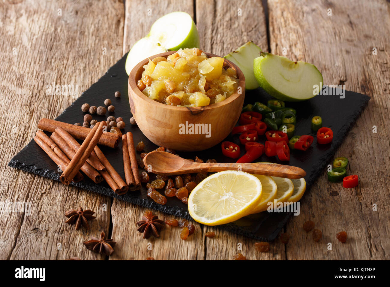 Mostarda di mele speziate con ingredienti di close-up in una ciotola sul tavolo. orizzontale, rustico Foto Stock