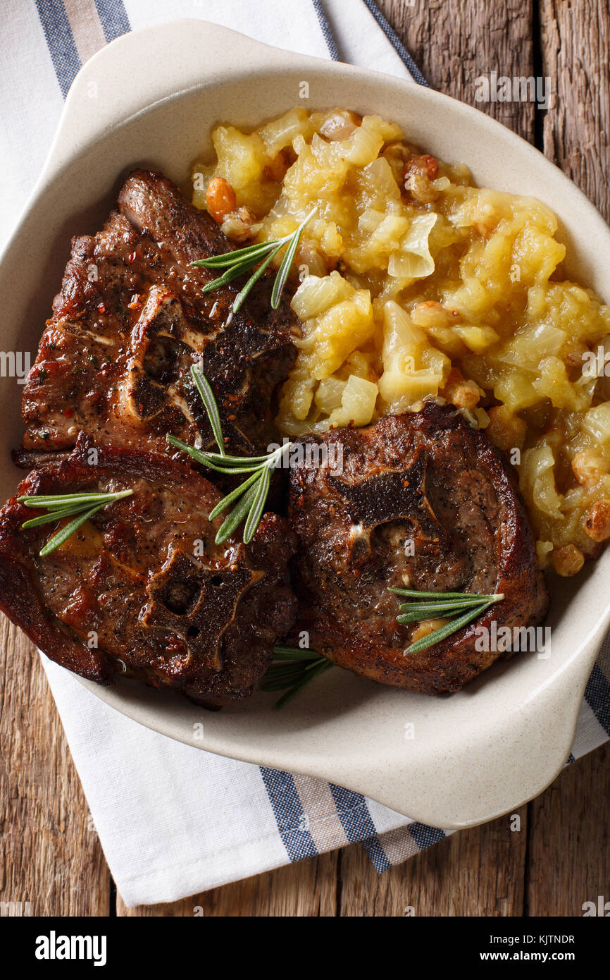Bistecca di agnello con rosmarino e chutney di Apple in una ciotola di close-up. verticale in alto vista da sopra Foto Stock