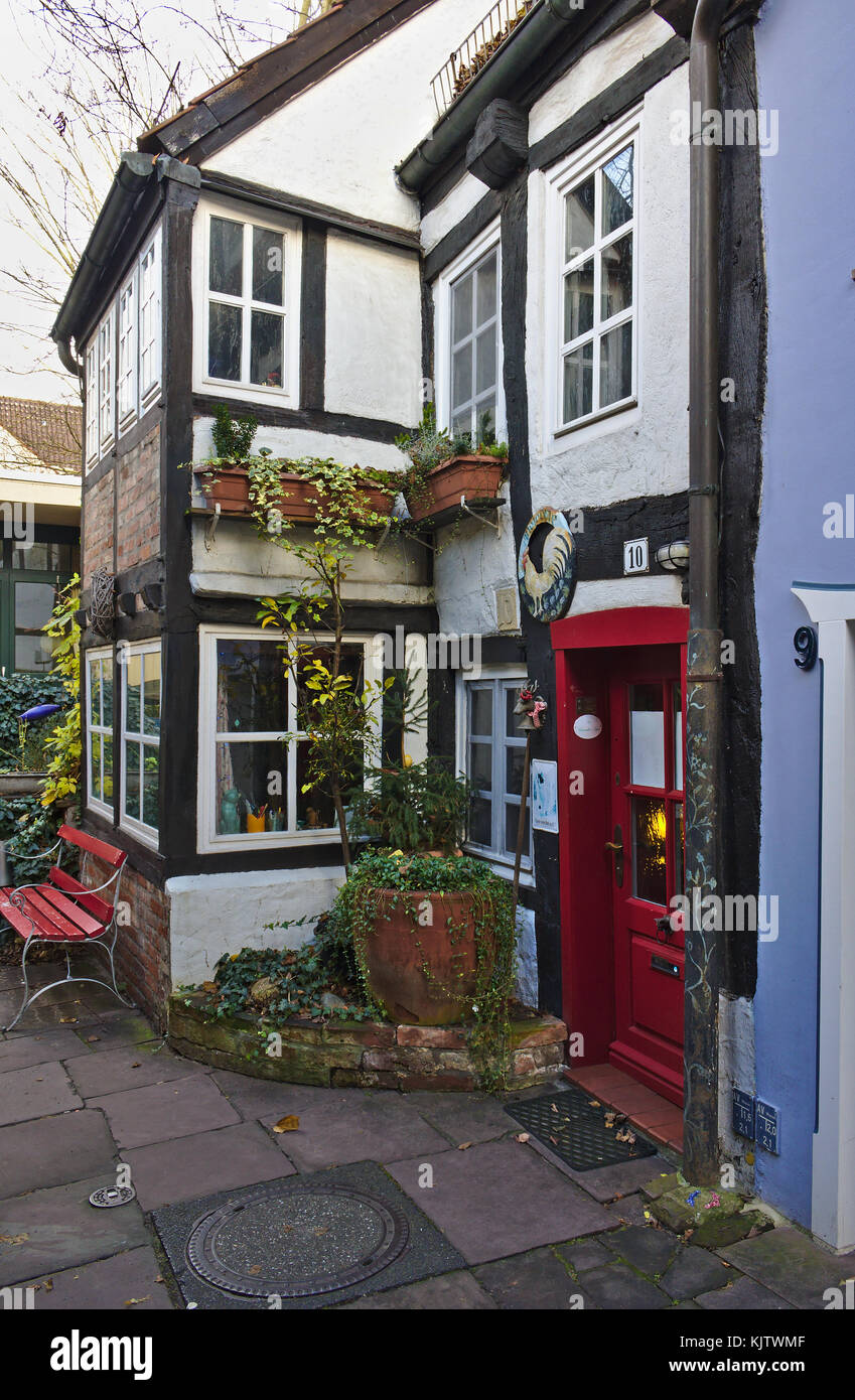 Brema, Germania - 23 novembre 2017 - Casa cittadina con struttura in legno bianco e porta rossa nello storico quartiere di Schnoor Foto Stock