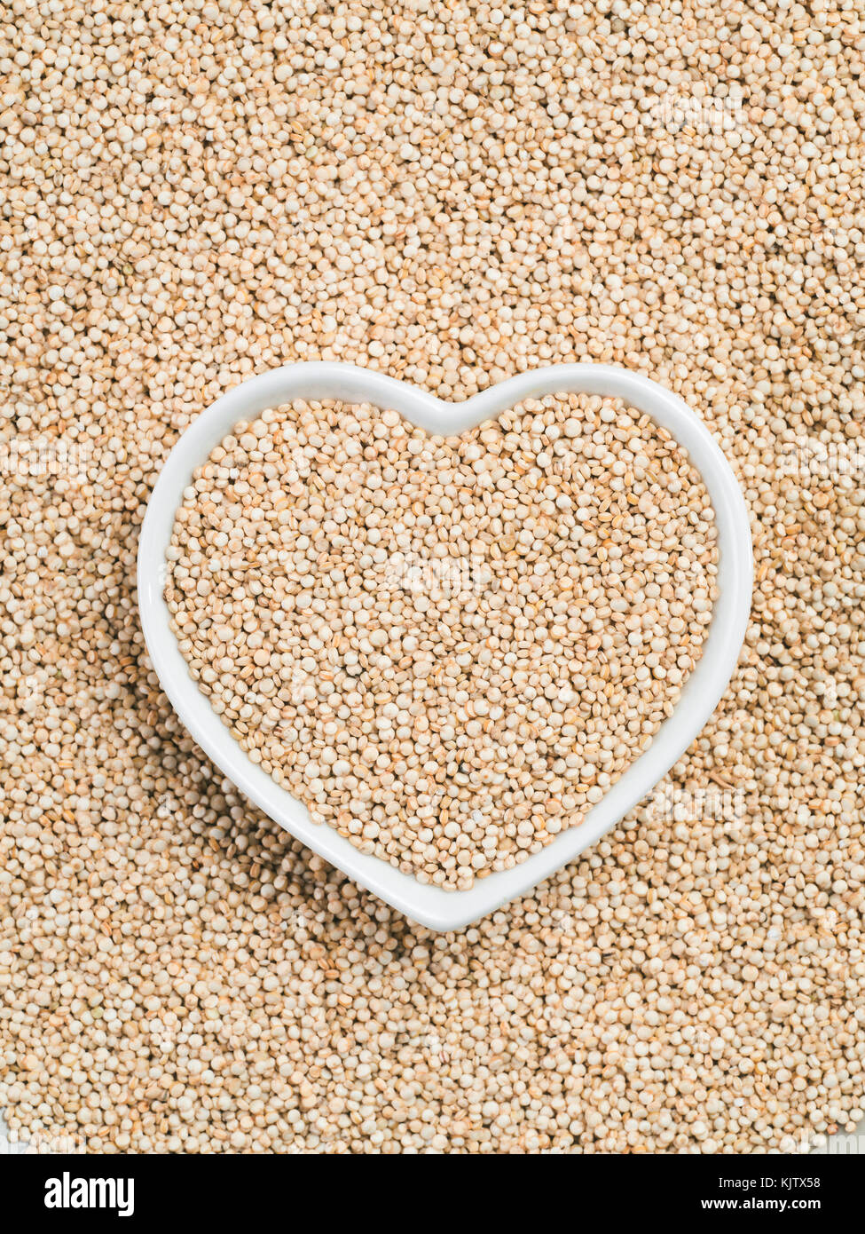 La quinoa in a forma di cuore sulla tazza di quinoa sfondo Foto Stock