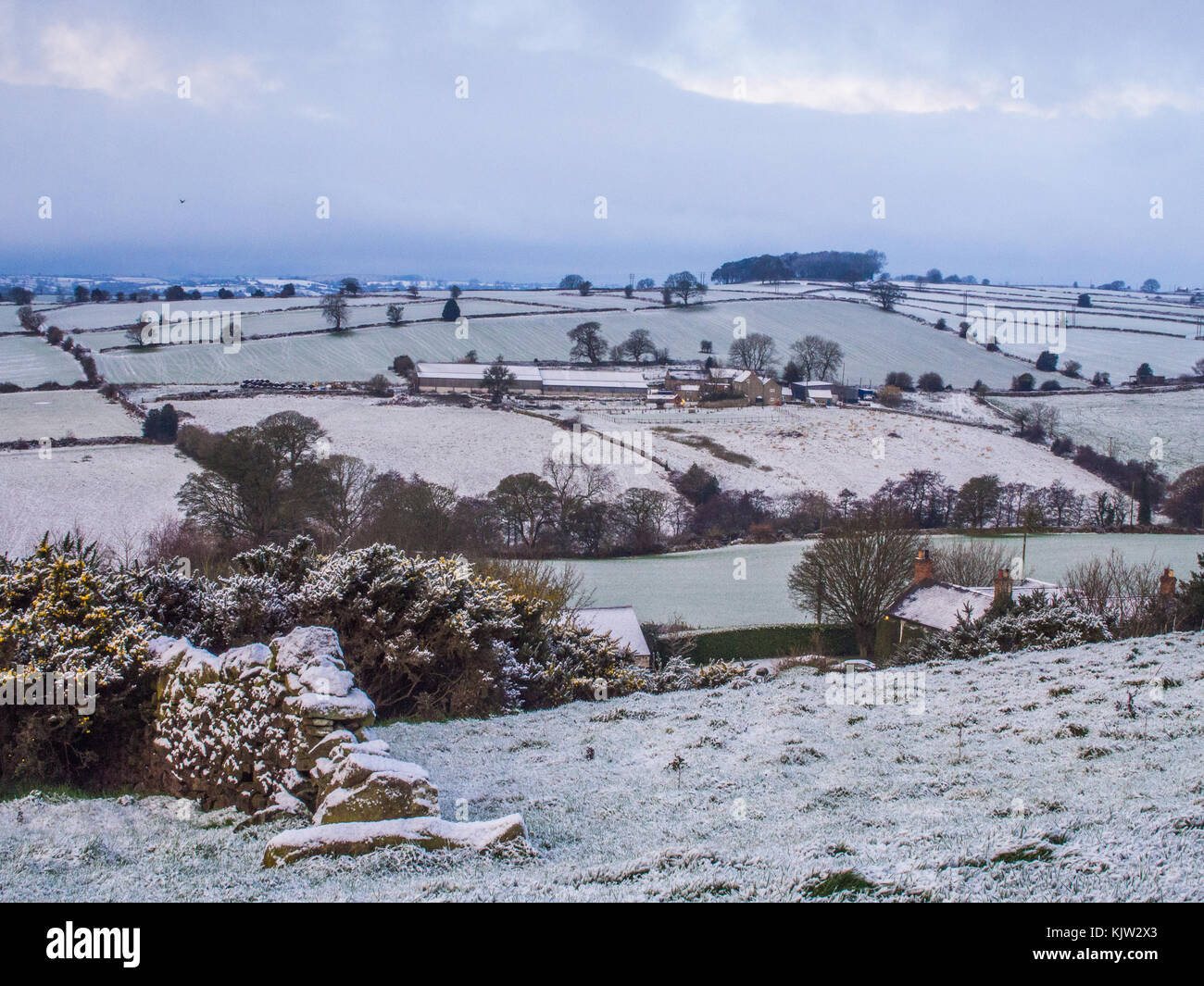 Scena Wintery vicino a Belper, Derbyshire, Inghilterra, con una casa colonica al centro dell'immagine Foto Stock