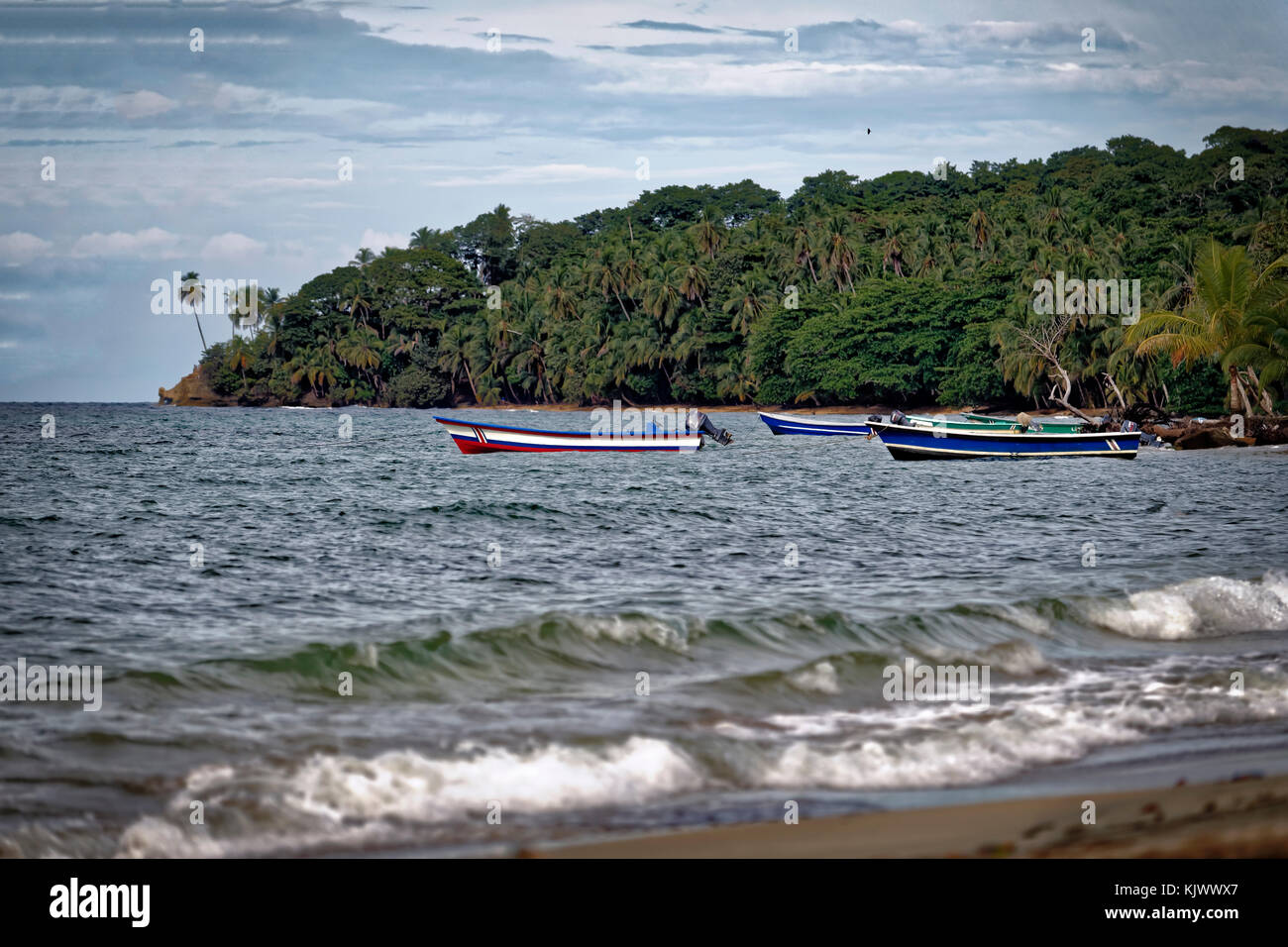 Colorate barche da pesca a Manzanillo, Costa Rica. Sono in bel contrasto con la giungla sullo sfondo. Foto Stock