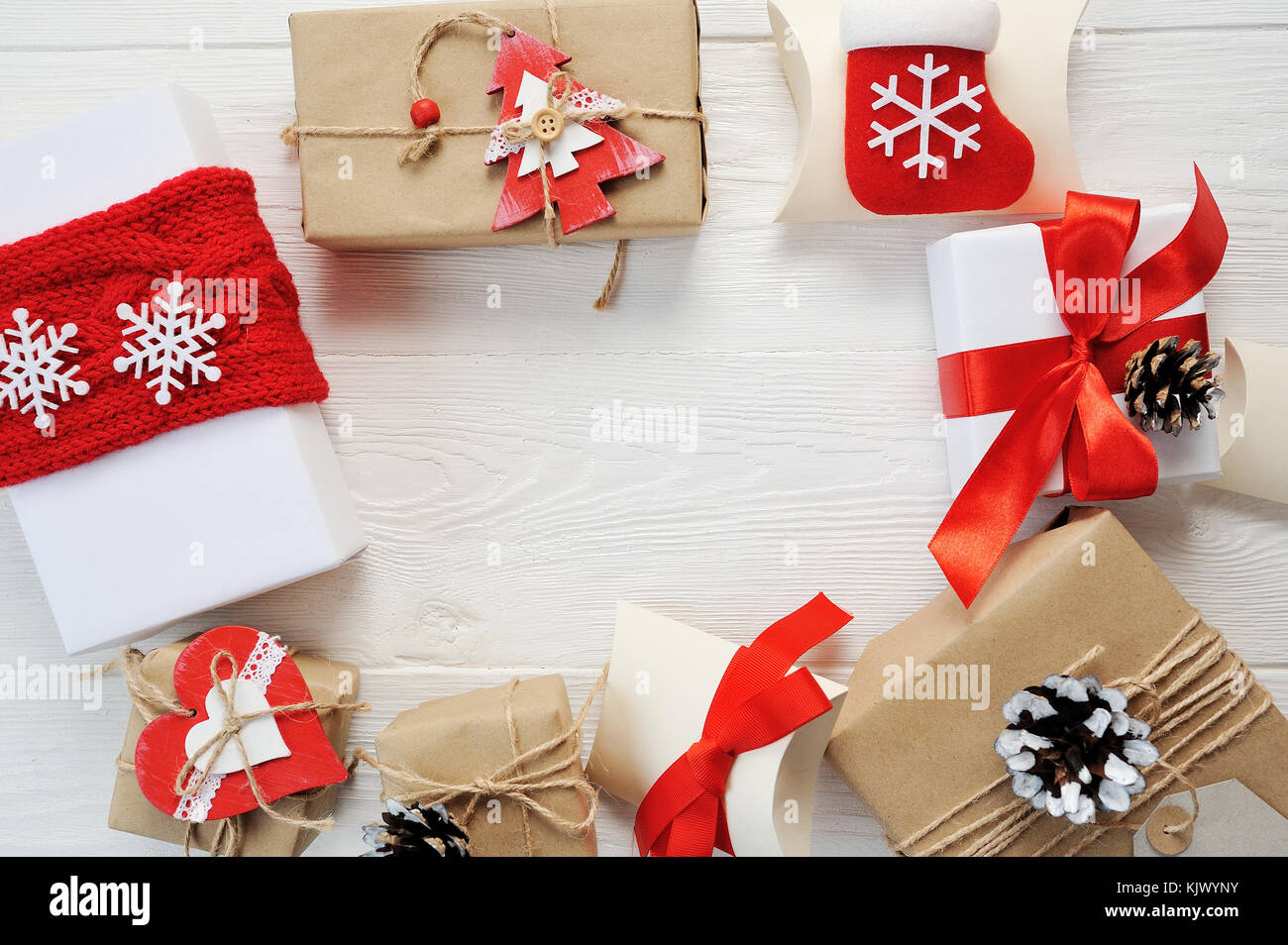 Mockup sfondo di Natale - Regalo di natale rosso regali box ed elementi di decorazione in bianco sullo sfondo di legno. piatti creativi e di layout vista superiore composizione con bordo e copiare il design dello spazio Foto Stock