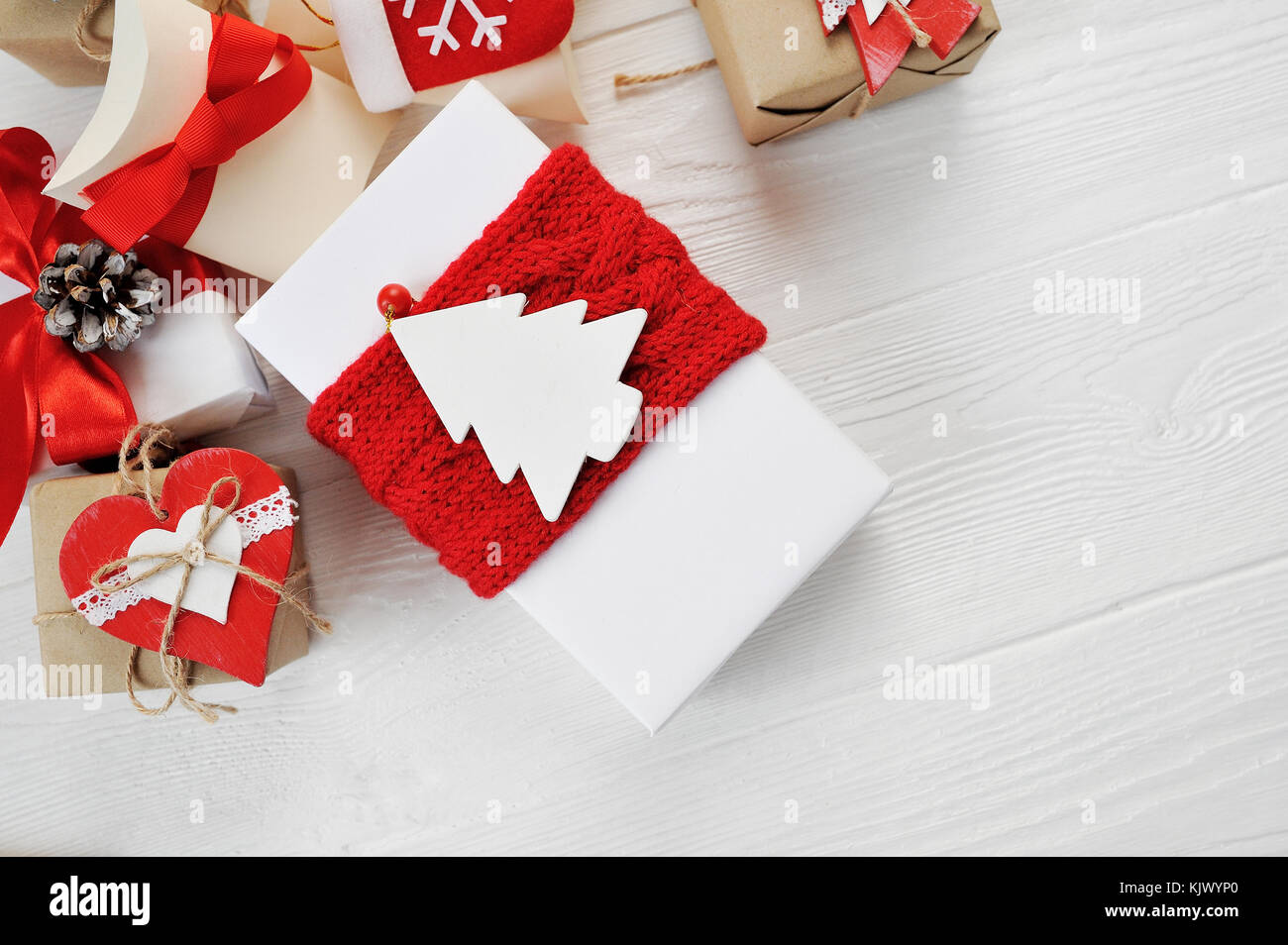 Natale regalo Scatole decorate con archetti in rosso su bianco sullo sfondo di legno. flat laico, top view photo mockup Foto Stock