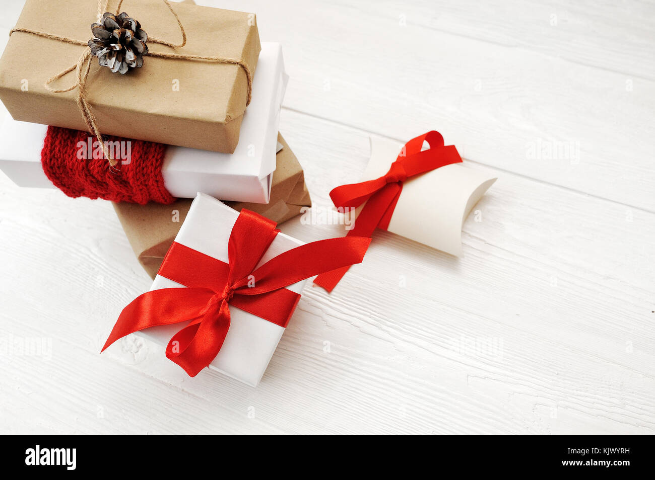 Mockup Natale sfondo con decorazioni rosse e confezioni regalo su tavola di legno con spazio di copia Foto Stock