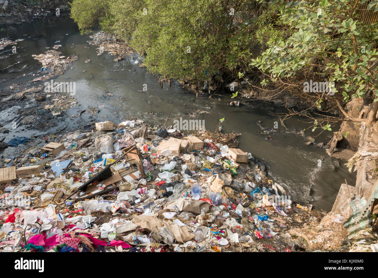 Sacchetti di plastica, i rifiuti domestici e liquame crea forte inquinamento nel fiume a Juhu di Mumbai Foto Stock