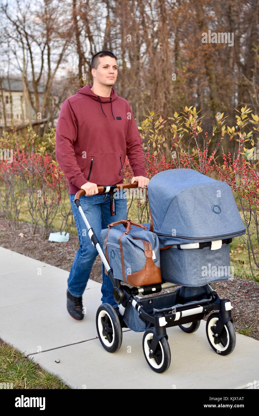 Papà spingendo bugaboo passeggino giù il marciapiede Foto Stock