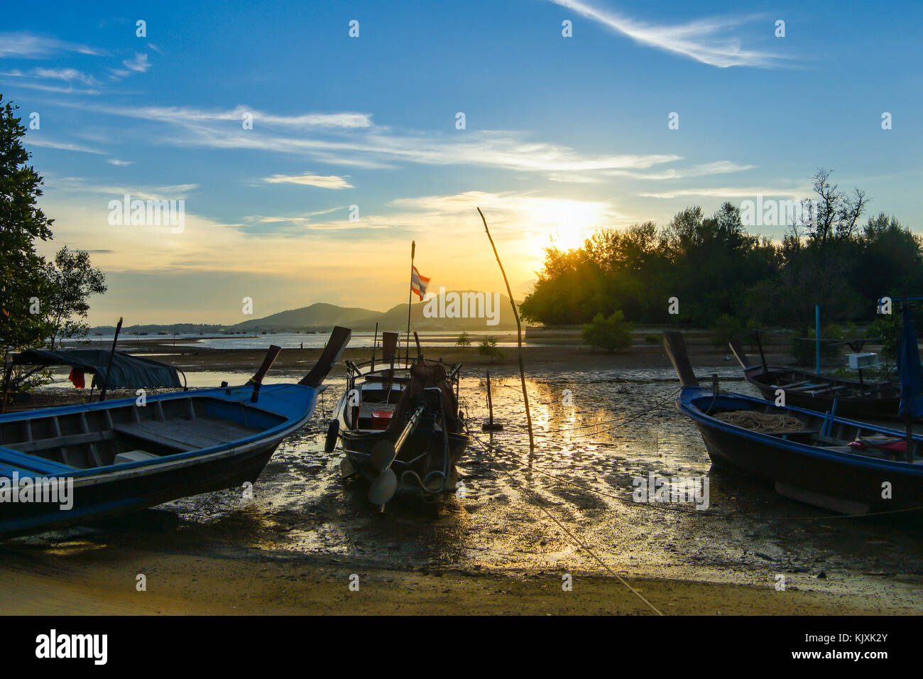 Coda lunga barca da pesca parcheggiato presso la spiaggia e il mare è inferiore. Lo sfondo è il tramonto e nuvoloso cielo blu. Foto Stock