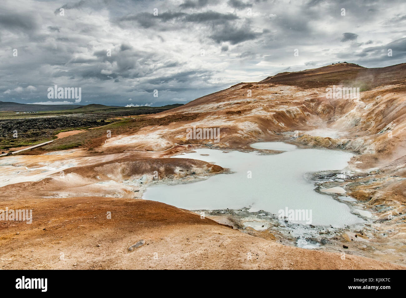Il solfatares crea un laghetto lattiginoso sulla orange e minerale pendici del vulcano Krafla Foto Stock
