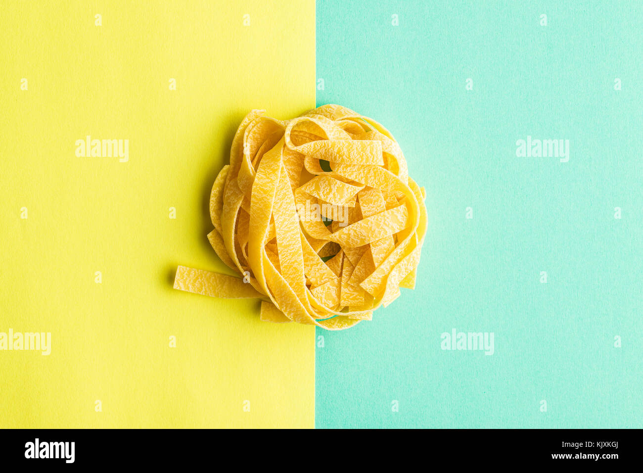 Lay piatto di tagliatelle sul doppio sfondo colorato. Foto Stock
