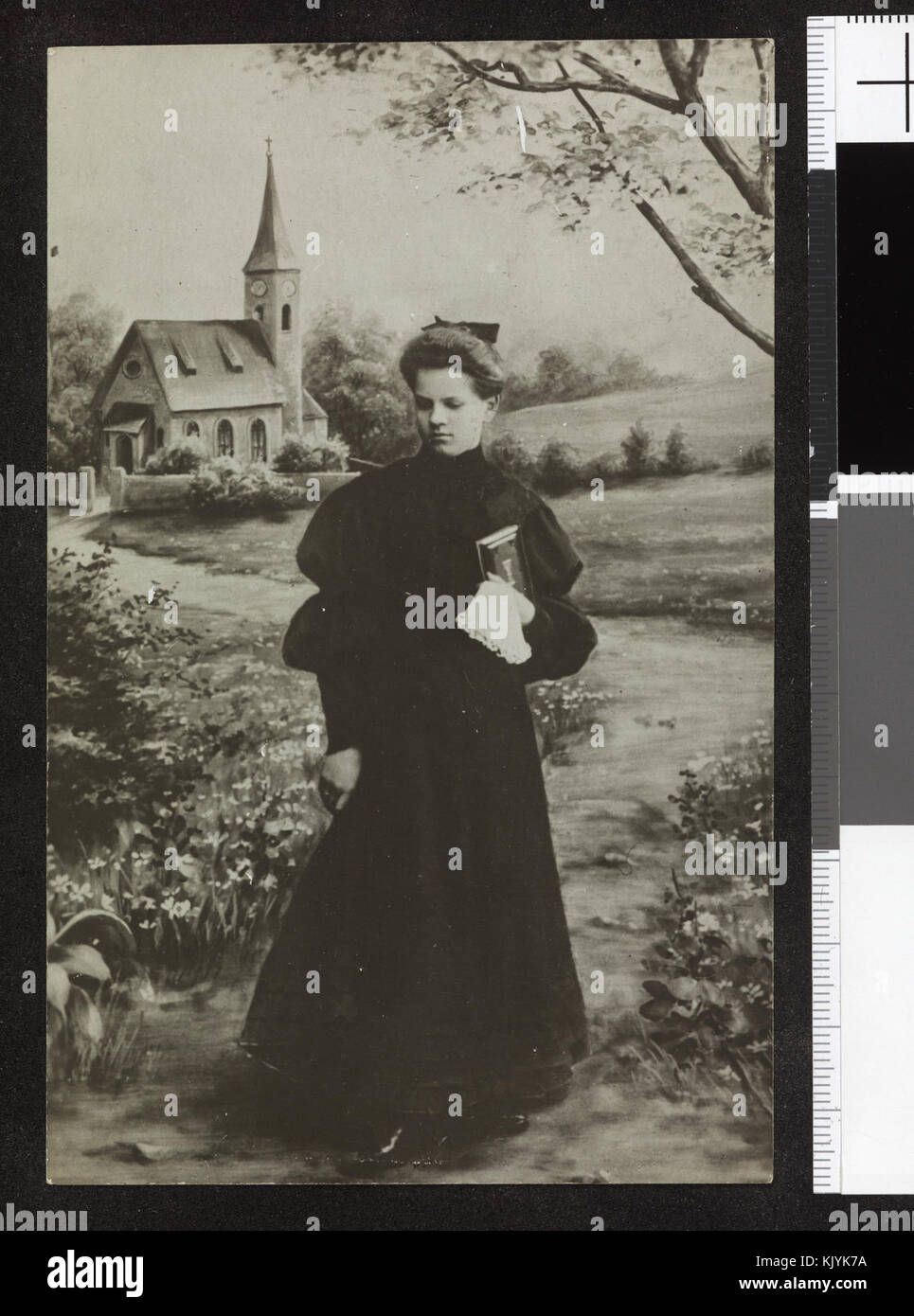 Una fotografia del 1905 circa raffigurante una ragazza in un abito scuro che tiene sotto il braccio una Bibbia, scattata in un ambiente di chiesa durante una cerimonia di conferma, che riflette le pratiche religiose e culturali del tempo. Foto Stock