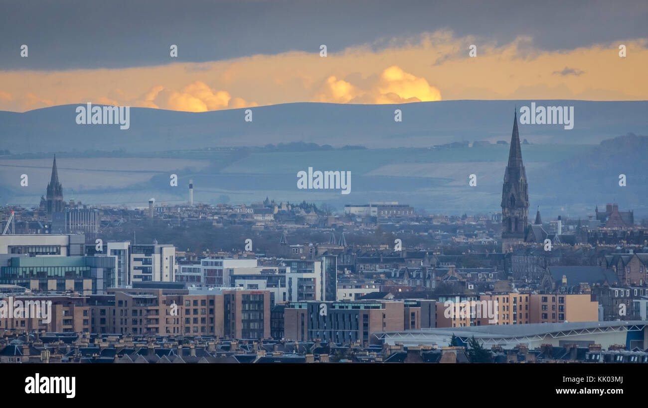 Vista dello skyline di Edimburgo, dei palazzi e degli edifici moderni e delle guglie della chiesa al tramonto con il cielo arancione, Scozia, Regno Unito Foto Stock