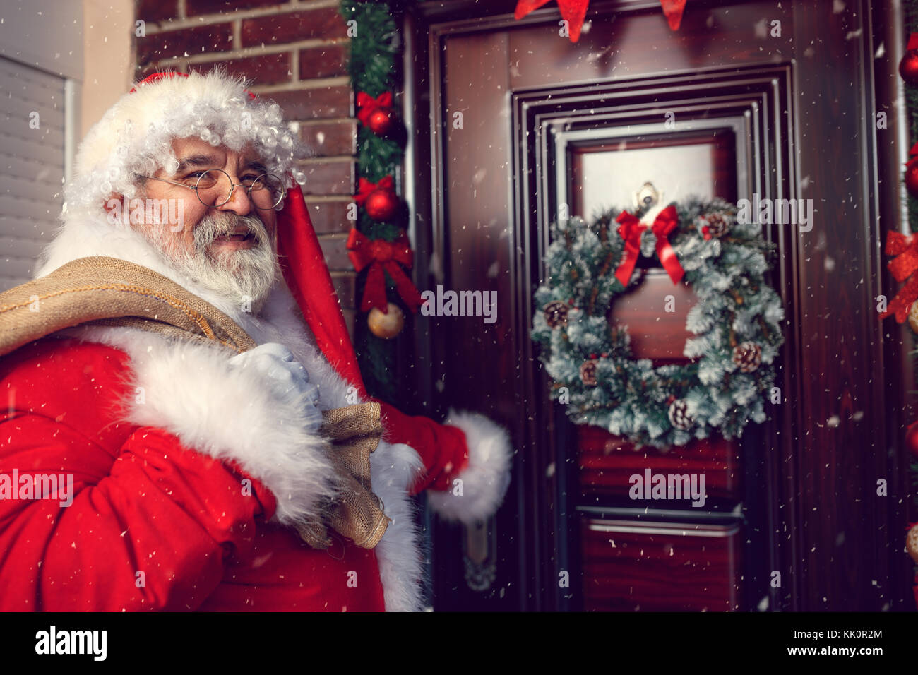 Sorridente Babbo Natale con sacco fronte della porta di natale Foto Stock