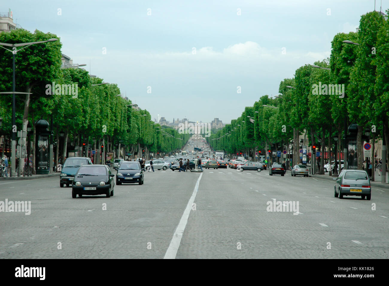 Il traffico automobilistico su Champs-Élysées Avenue a Parigi che conduce fino alla rotatoria di Arc de Triomphe Foto Stock