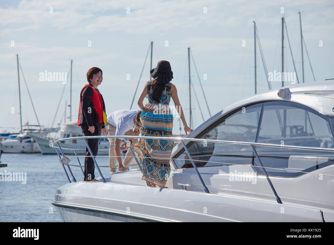 Immagine dello stile di vita del personale e la gente di vendite accogliente una femmina di cliente a bordo di una barca show. Foto Stock